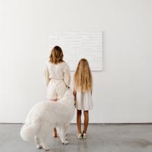 mother, daughter, and dog in front of painting 