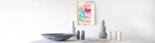 table with ceramic sculptural vases in white and grey, abstract artwork n canvas with grommets above in green blue red pink and orange  